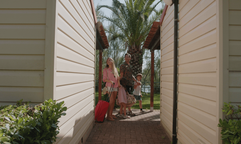 Famiglia in vacanza tra bungalow e palme.